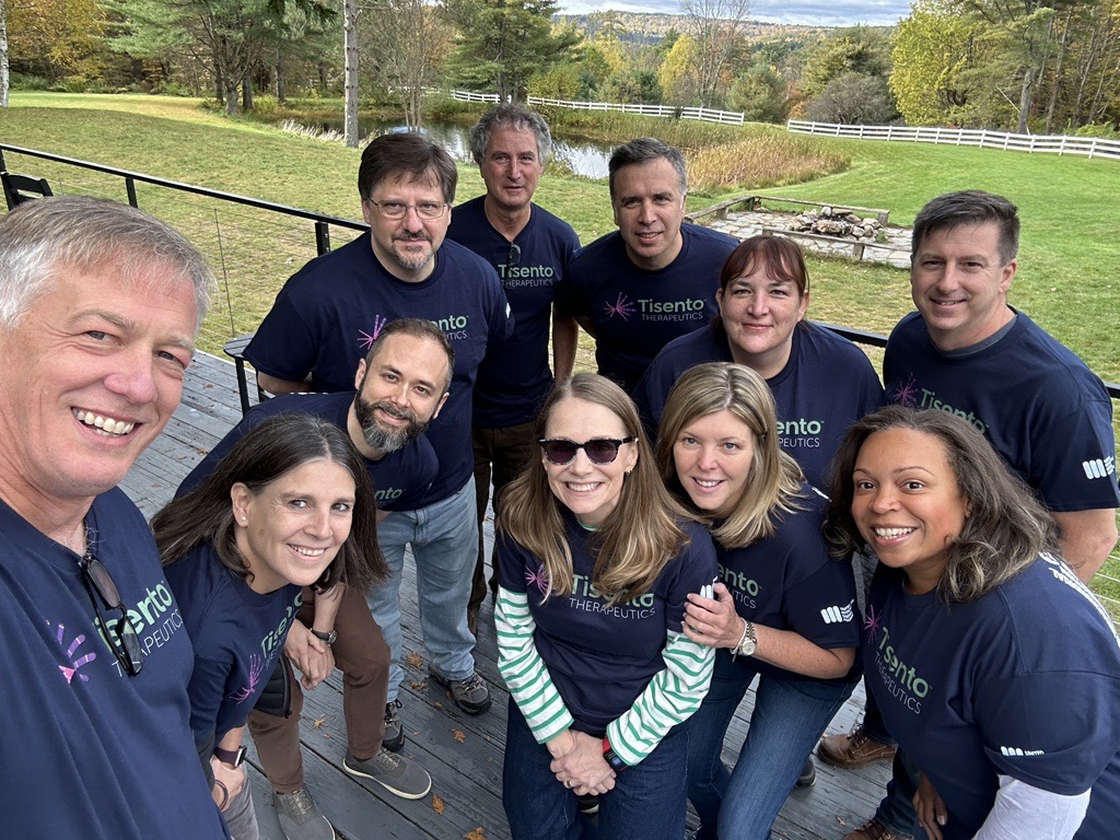 11 members of the Tisento Therapeutics team stand together and smile at the camera for a selfie during the UMDF Walkathon (2023). 